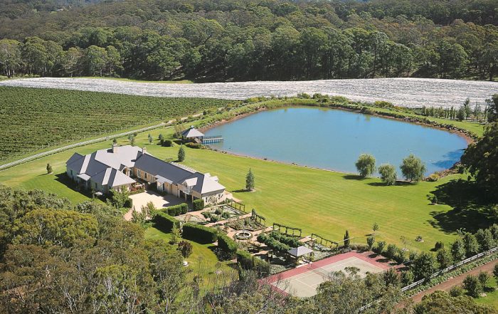 Aerial view of a Southern Highlands country property with the house garden, dam and tennis court set within paddocks and bushland