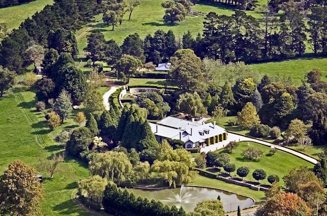 Aerial view of a Southern Highlands country estate with a long row of conifers and blocks of trees sheltering the house garden from the paddocks